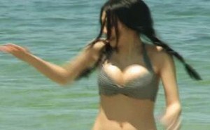 美女走在沙滩上玩水的女人
